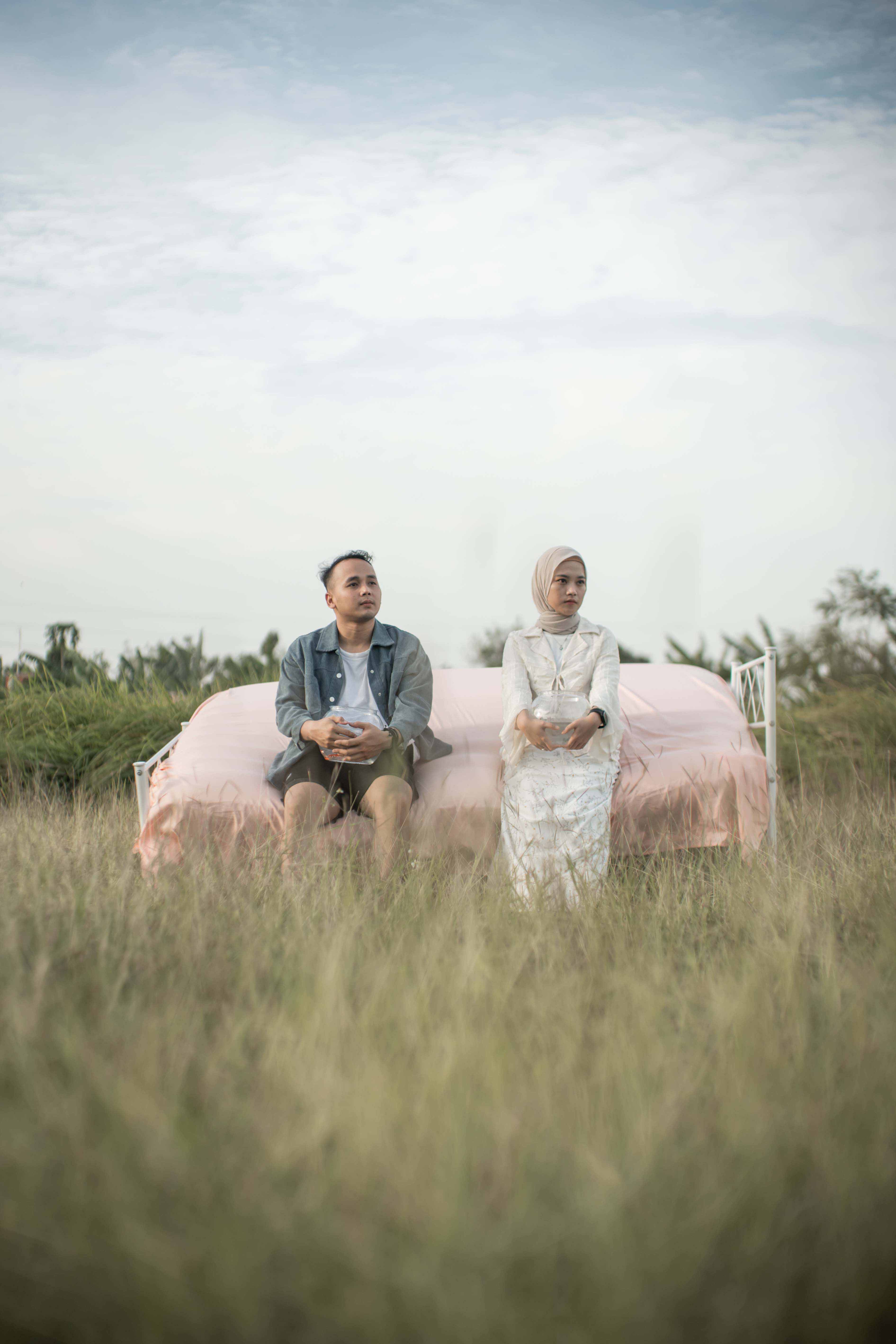 Pasangan duduk bersama di padang rumput
